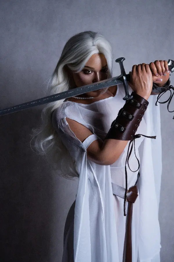 Detail of buckled leather bracers on Selena's forearms.