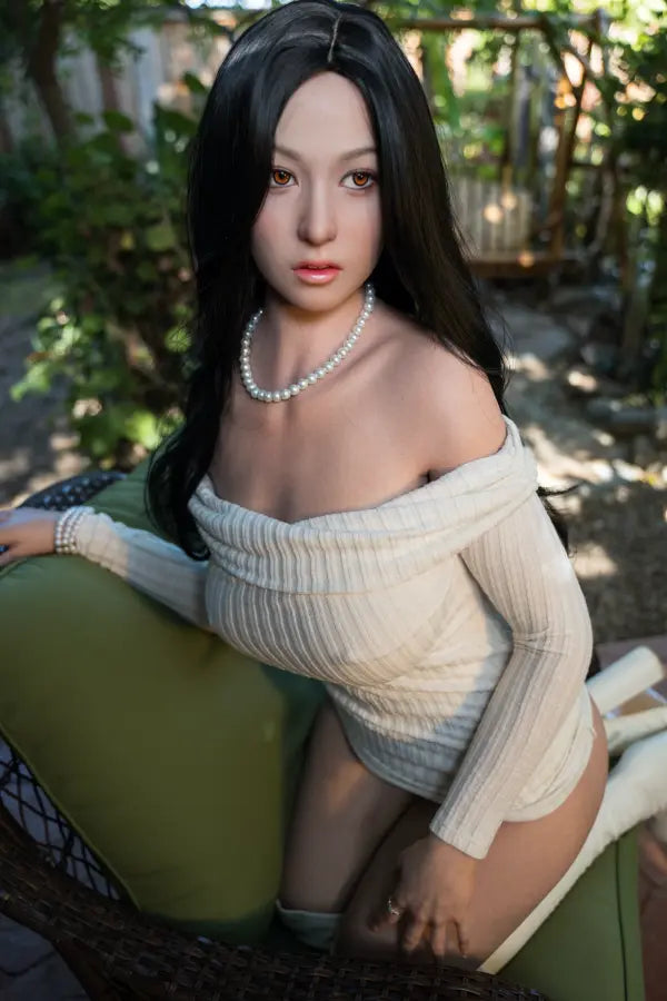 Close-up of WanZhi’s East Asian face with pearl necklace and high-end black wig.